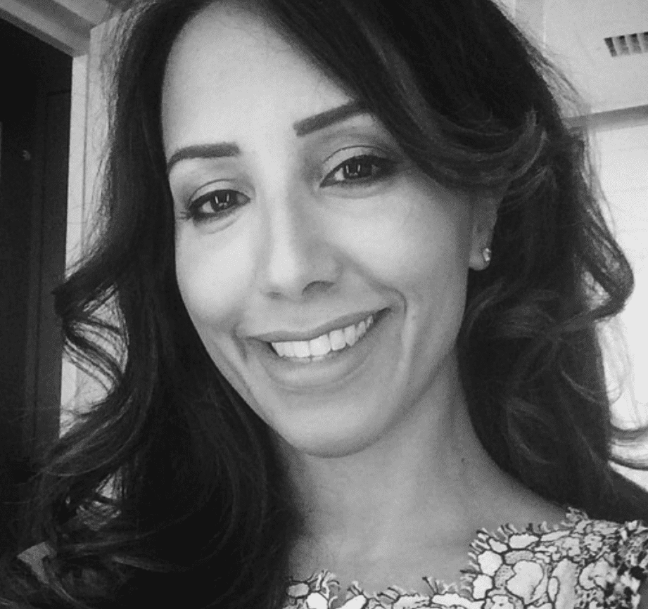 Smiling woman with long curly hair in grayscale