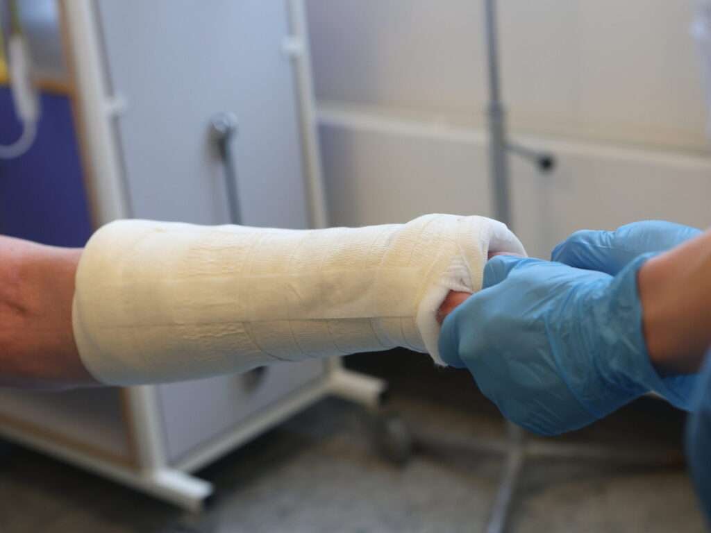 Doctor examines a bandaged arm in a hospital.